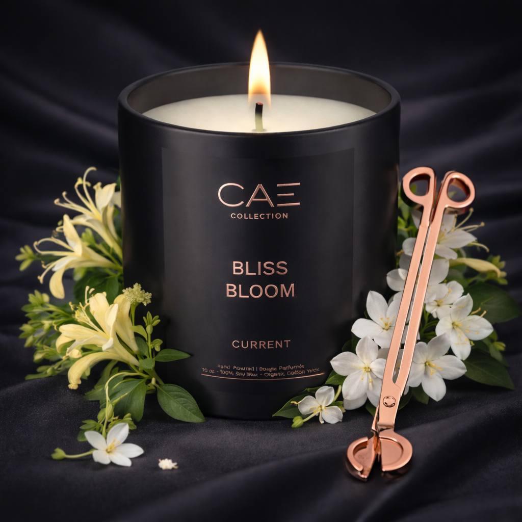 Black candle with 'CAE Collection' branding, surrounded by Jasmine and honey suckle and a candle trimmer on a dark background