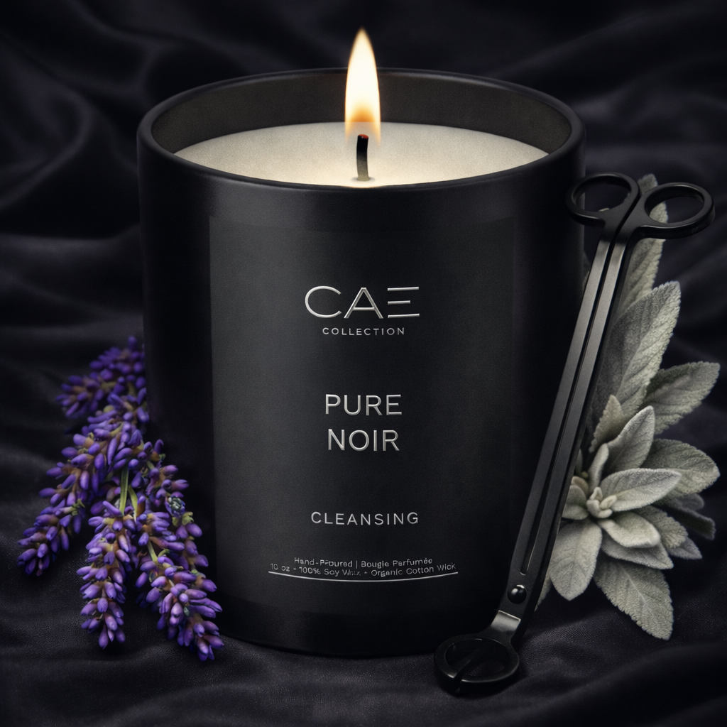 Black candle labeled 'Pure Noir' with lavender and white sage and a candle trimmer on a dark background
